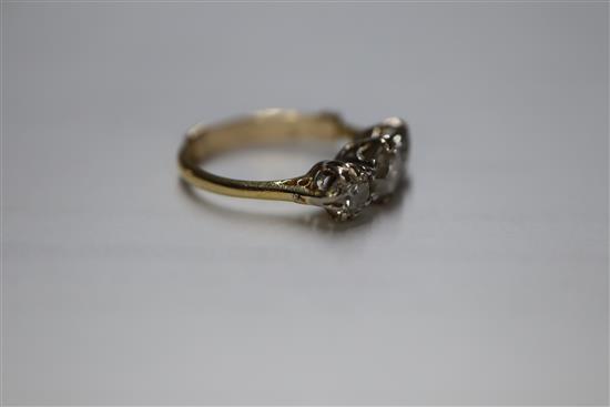 A yellow metal and three stone diamond ring, size H.